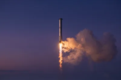 Illustration éditoriale d’un lanceur à deux étages en acier inoxydable en pleine ascension, panache d’échappement orange au-dessus d’un horizon brumeux